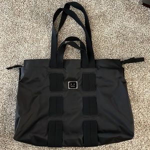 Acne Studios black nylon tote bag with metal face plate.